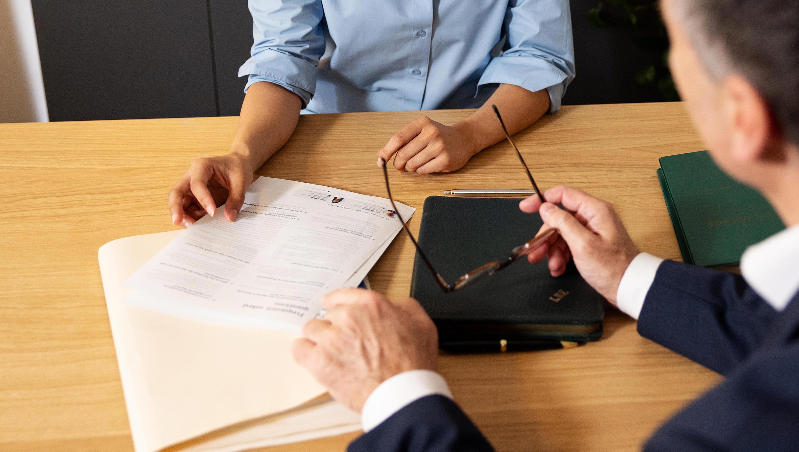 A close up of two people's hands as they pass eachother a document.