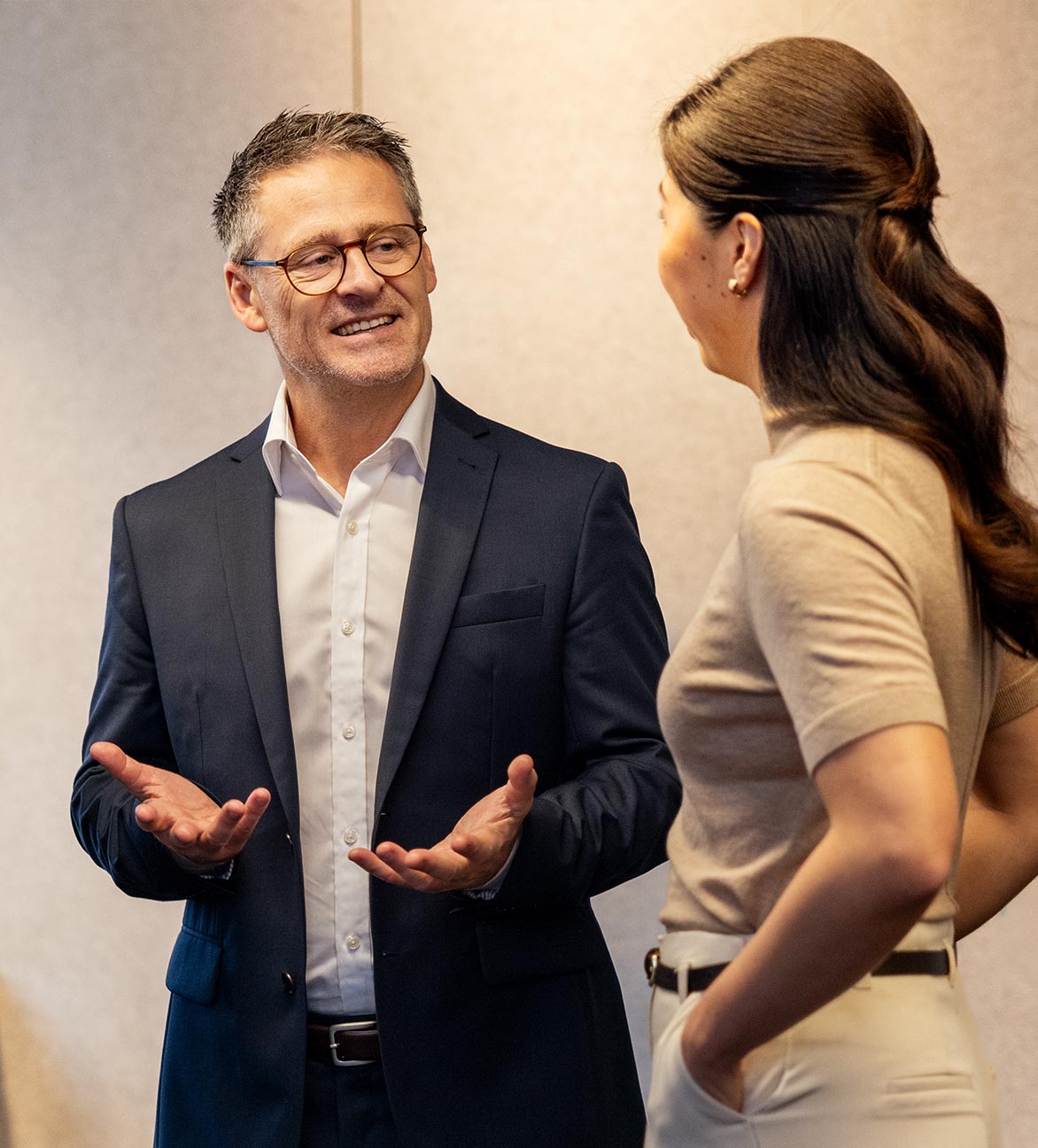 A man is talking to a woman, explaining with his hands.